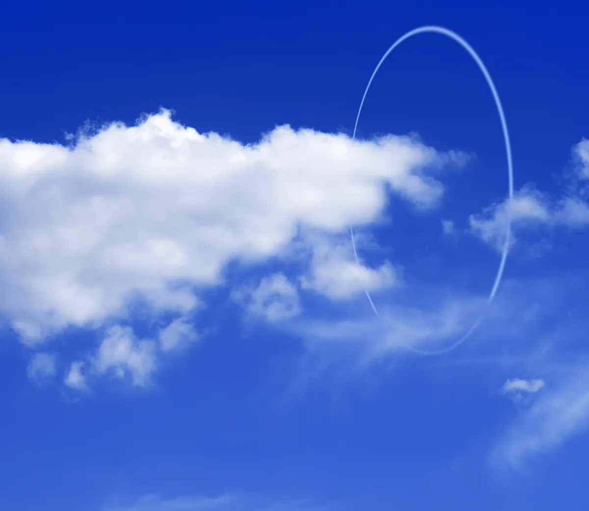 Una gran nube blanca y un aro de luz en el cielo azul